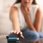 Unrecognizable Woman Reaching For Asthma Inhaler At Home, Selective Focus