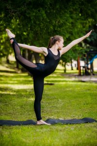 Balance exercise - young woman exercising in park