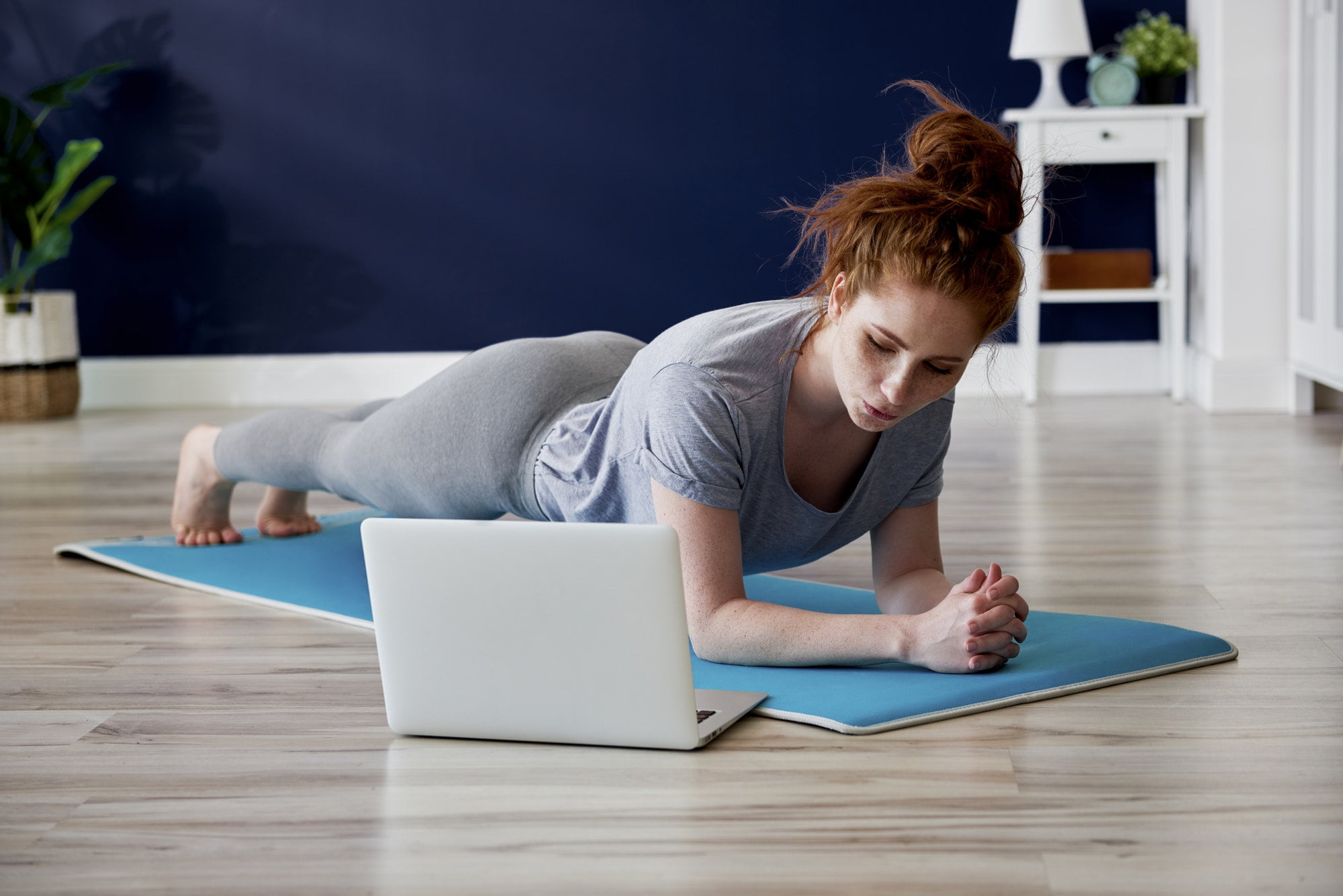 Redhead woman doing some yoga exercises at home