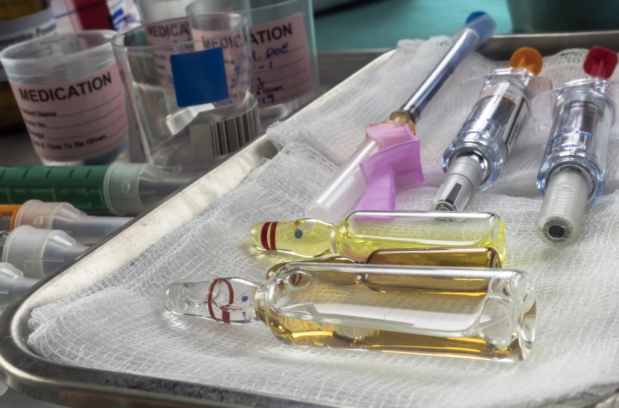 Diverse medication in glasses monodose along with insulin injectors in hospital, conceptual image