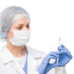 Nurse in protective mask, gloves and whitecoat holding syringe with vaccine