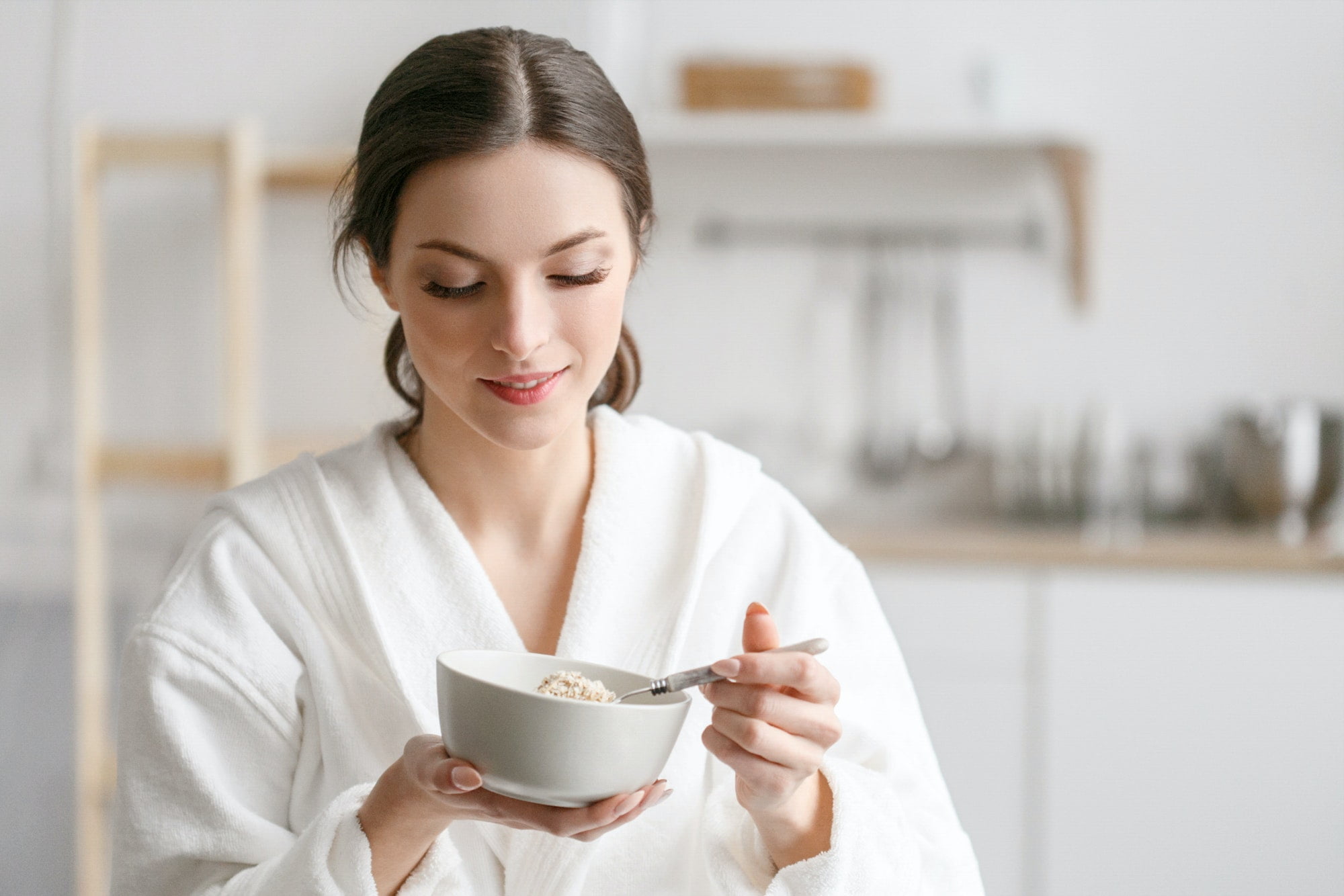 Woman eat in kitchen, woman with bowl breakfast home morning