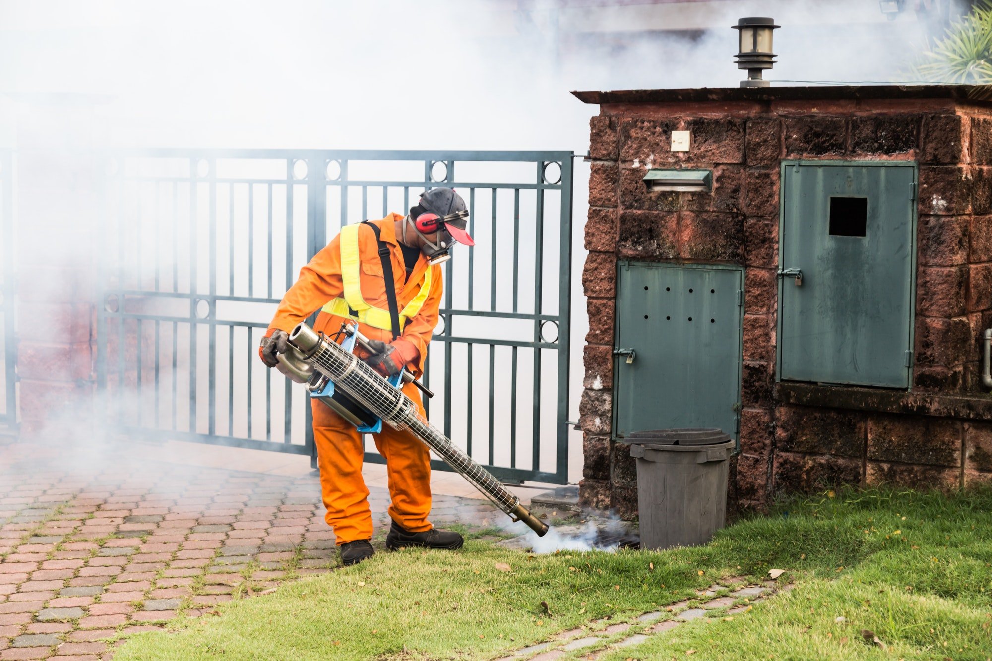 Worker fogging residential area with insecticides to kill aedes