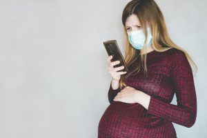 Young pregnant woman wearing a face mask