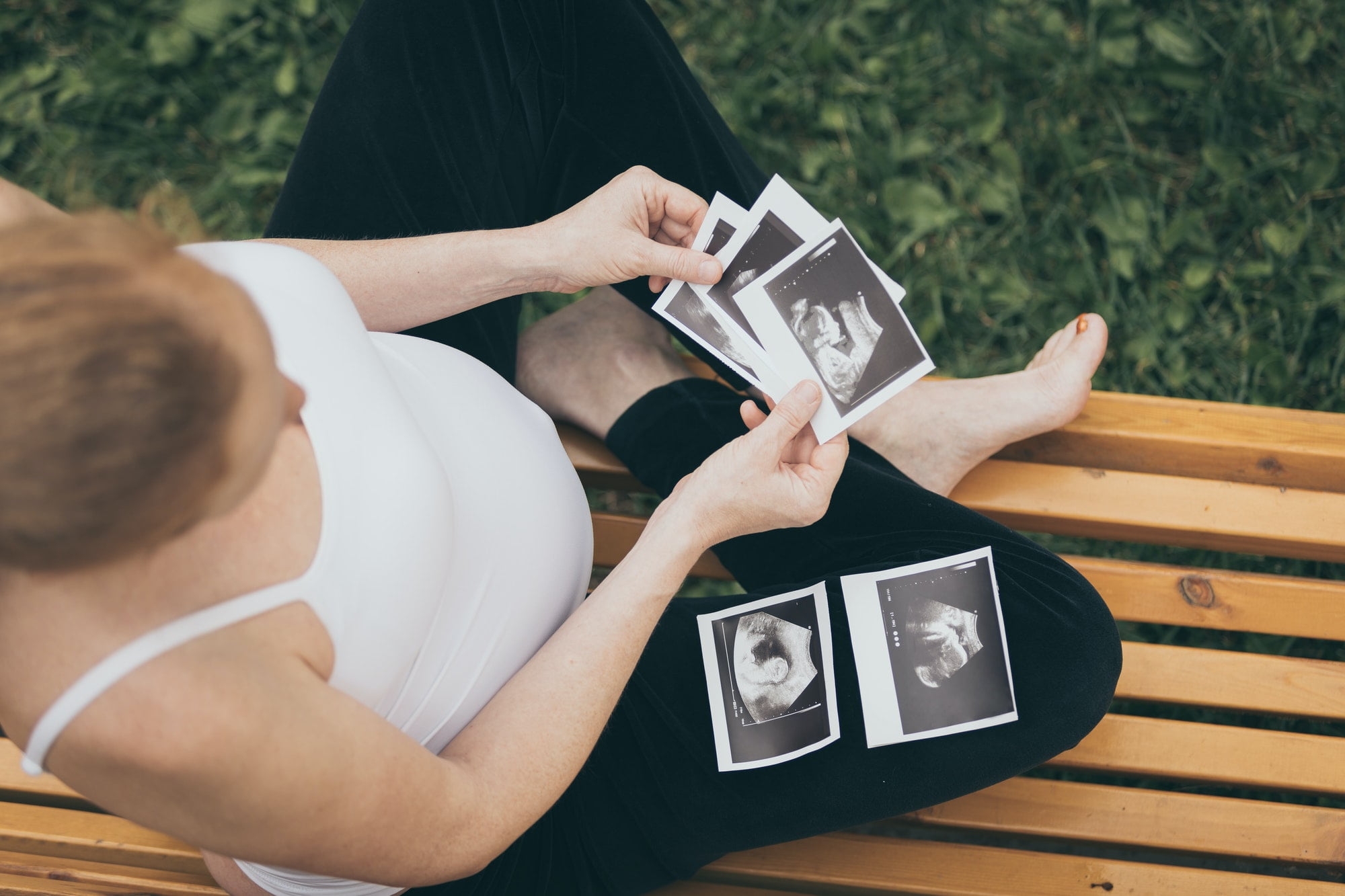 pregnant woman sitting on the bench and loocking ultrasound scan