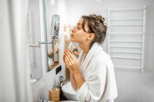 Woman looking on her skin at bathroom