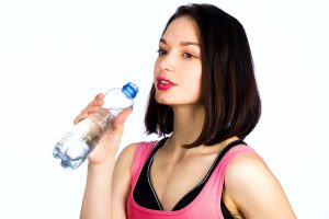 Young woman in sportswear with a bottle of drinking water