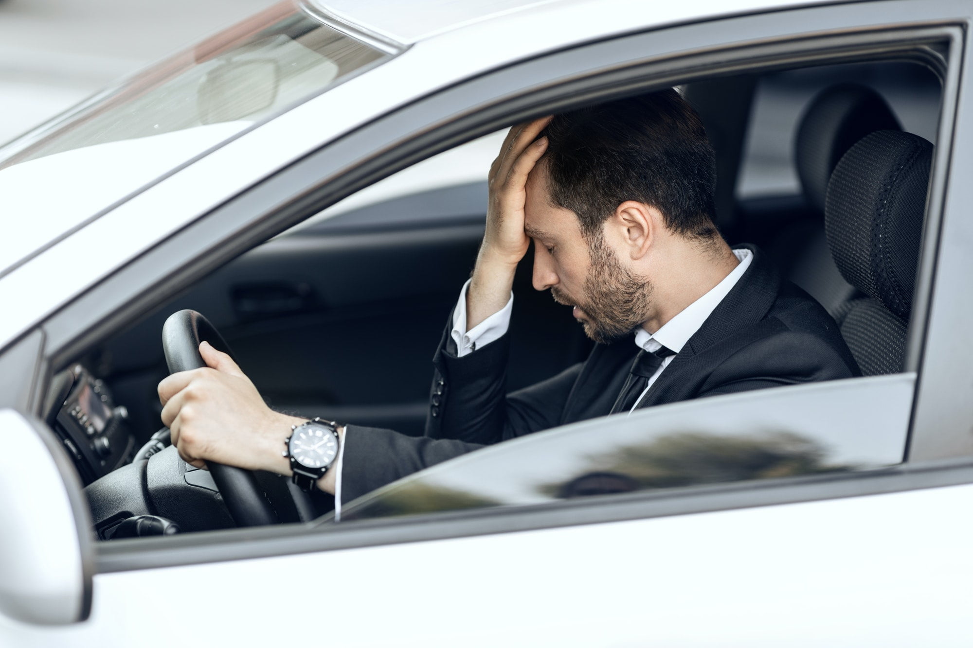 Stressed businessman stuck in traffic, late to airport