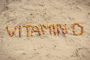 Vintage photo, Inscription vitamin D on sand at beach, summer time and healthy lifestyle concept